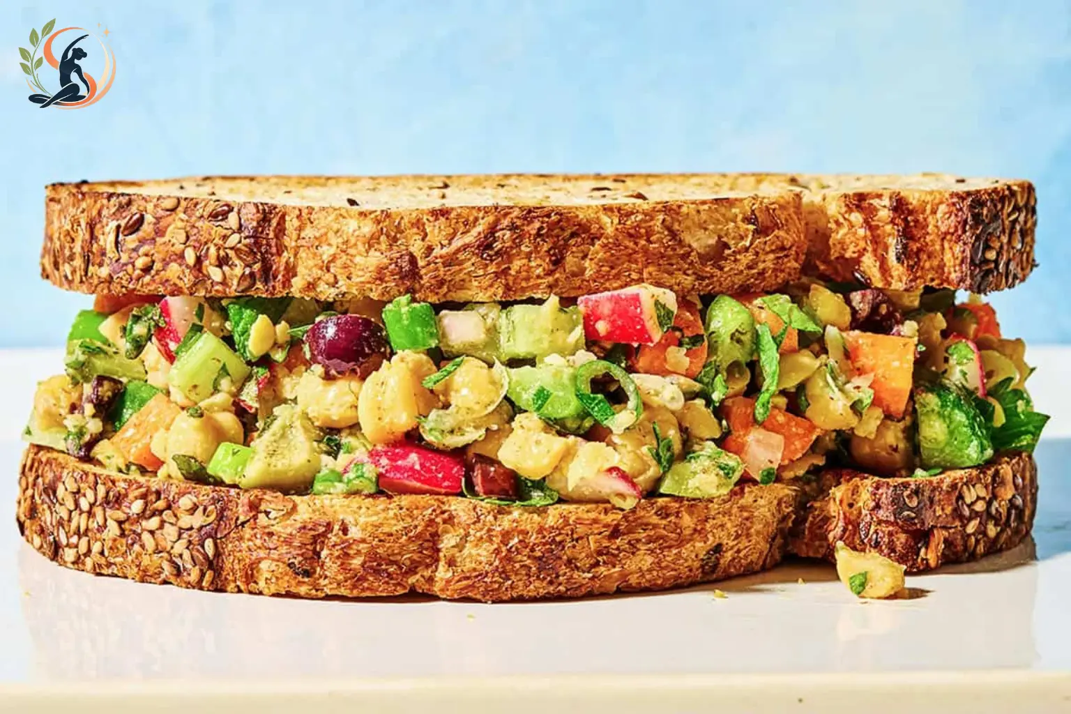 chickpea salad sandwich with lettuce and tomato on whole grain bread